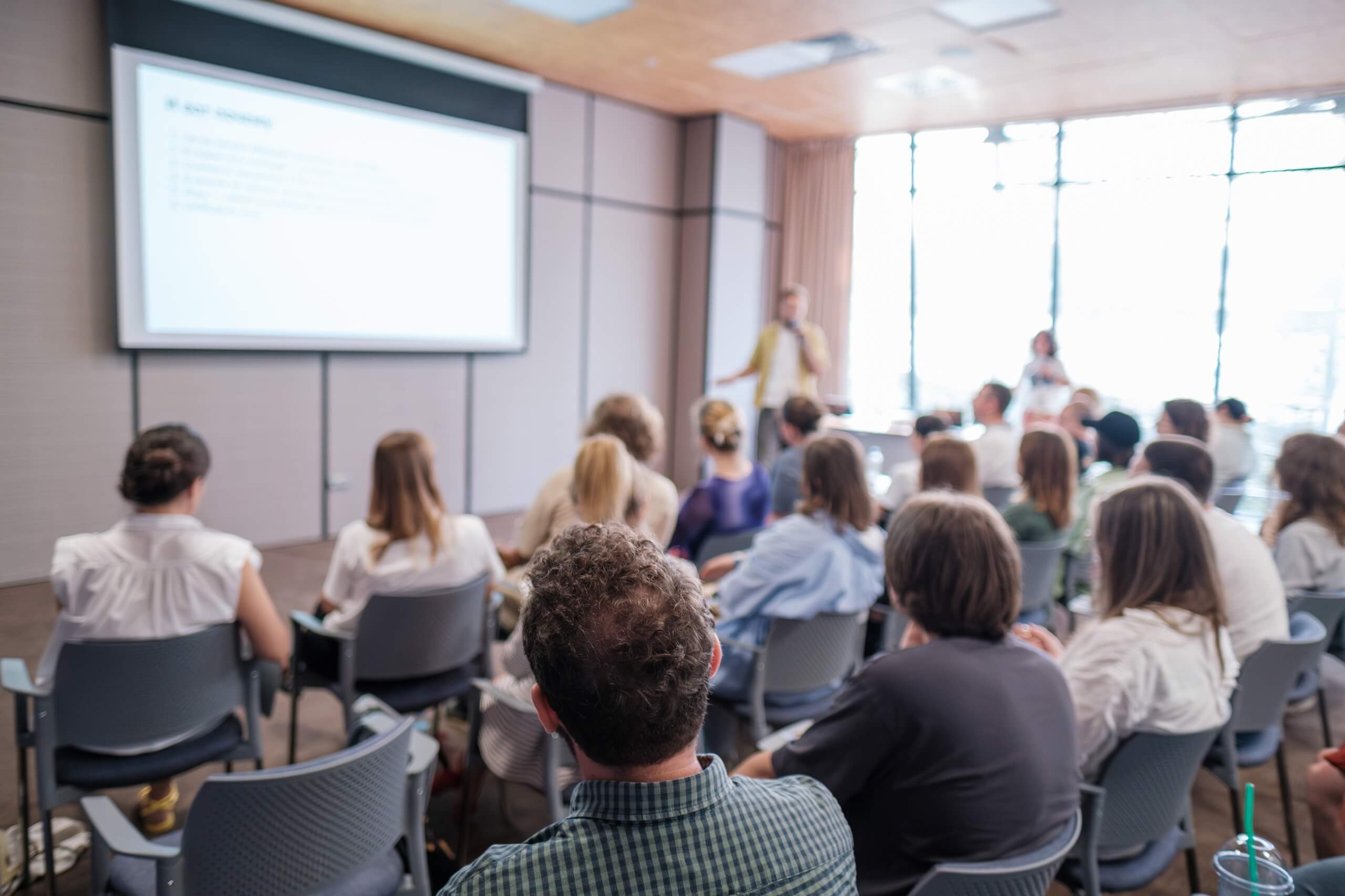 Deelnemers volgen een opleiding tijdens een presentatie in een professionele setting
